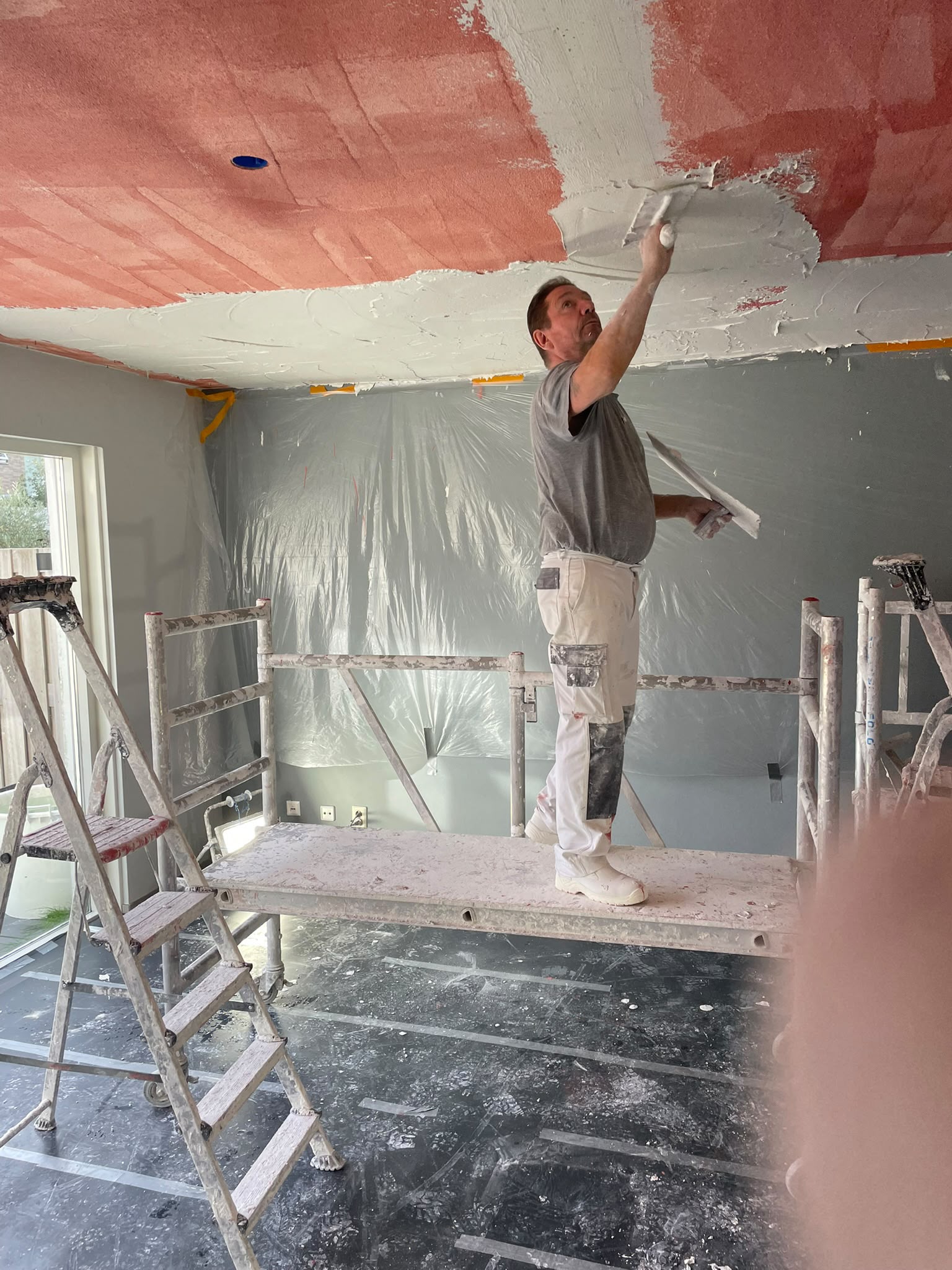 Mario brengt stucwerk aan op een plafond